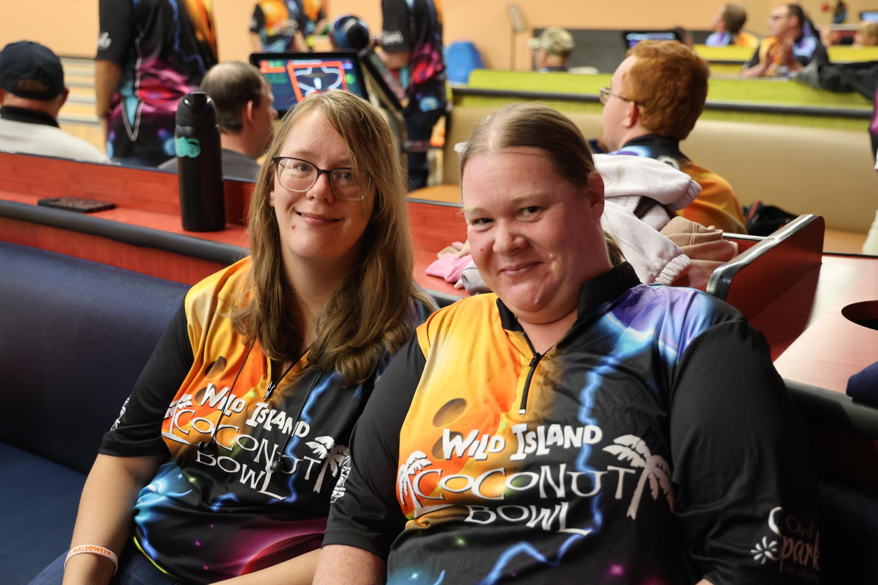 Two Leisure without Limits bowling league participants smiling. Both wearing Wild Island Coconut Bowl shirts. 
